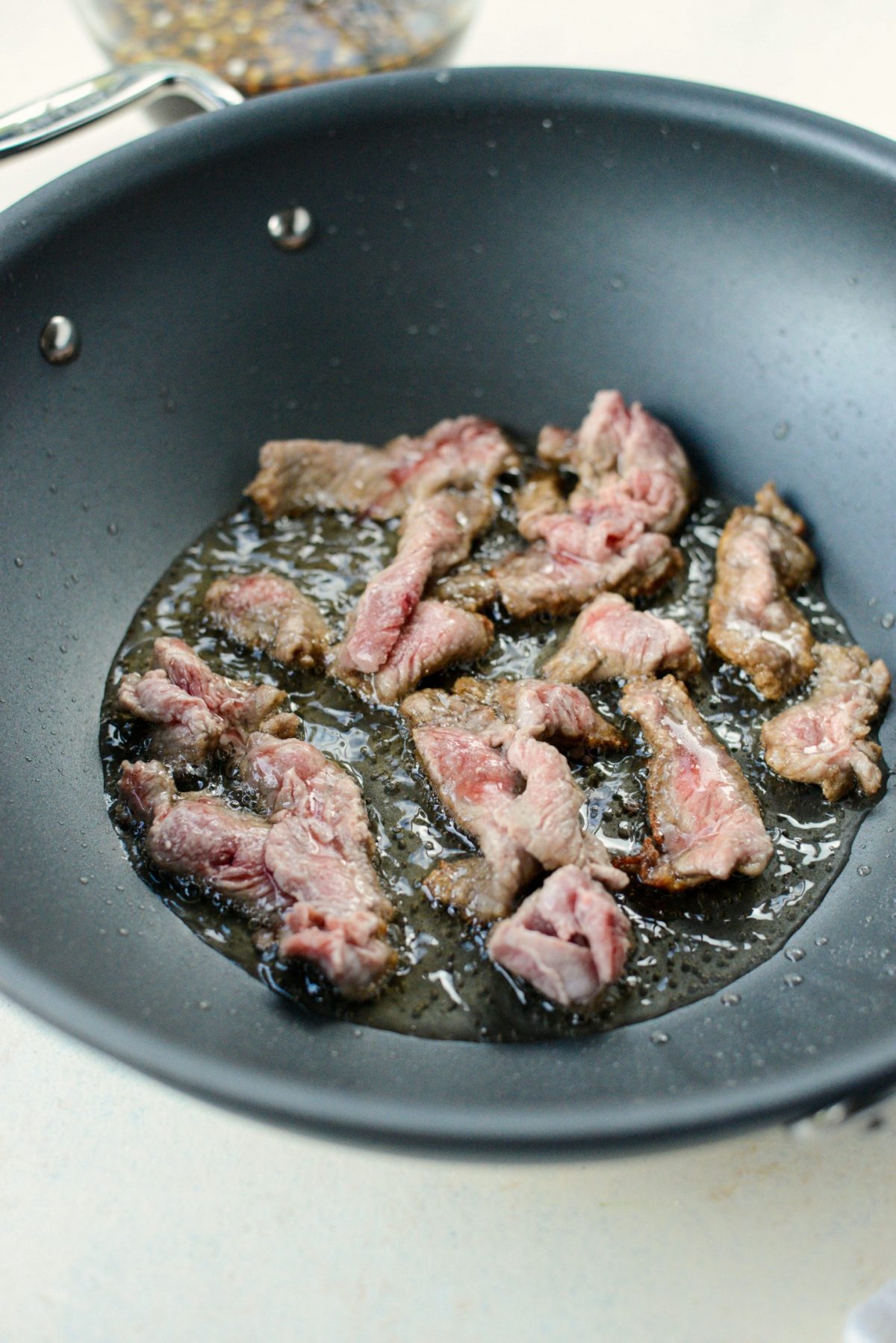 Working in batches cooking the beef in oil.