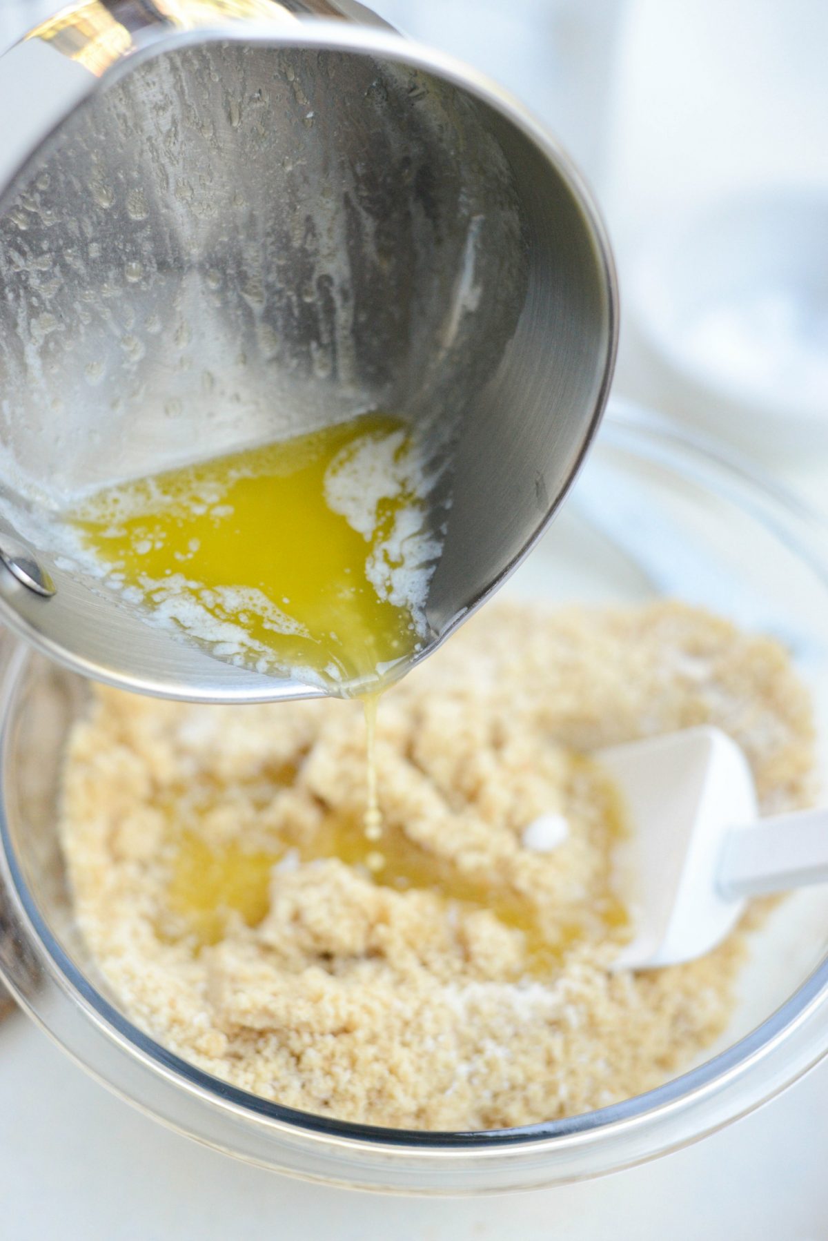 butter pouring into crust mixture 