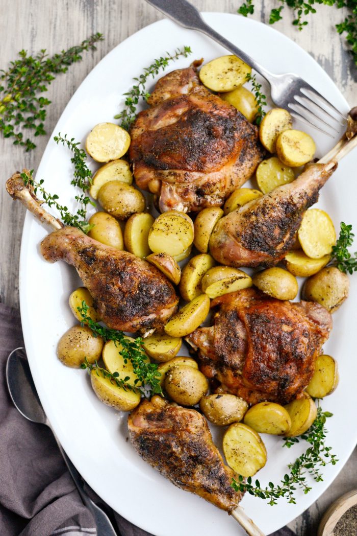 Roasted Turkey Thighs and Drumsticks and potatoes on a serving platter.