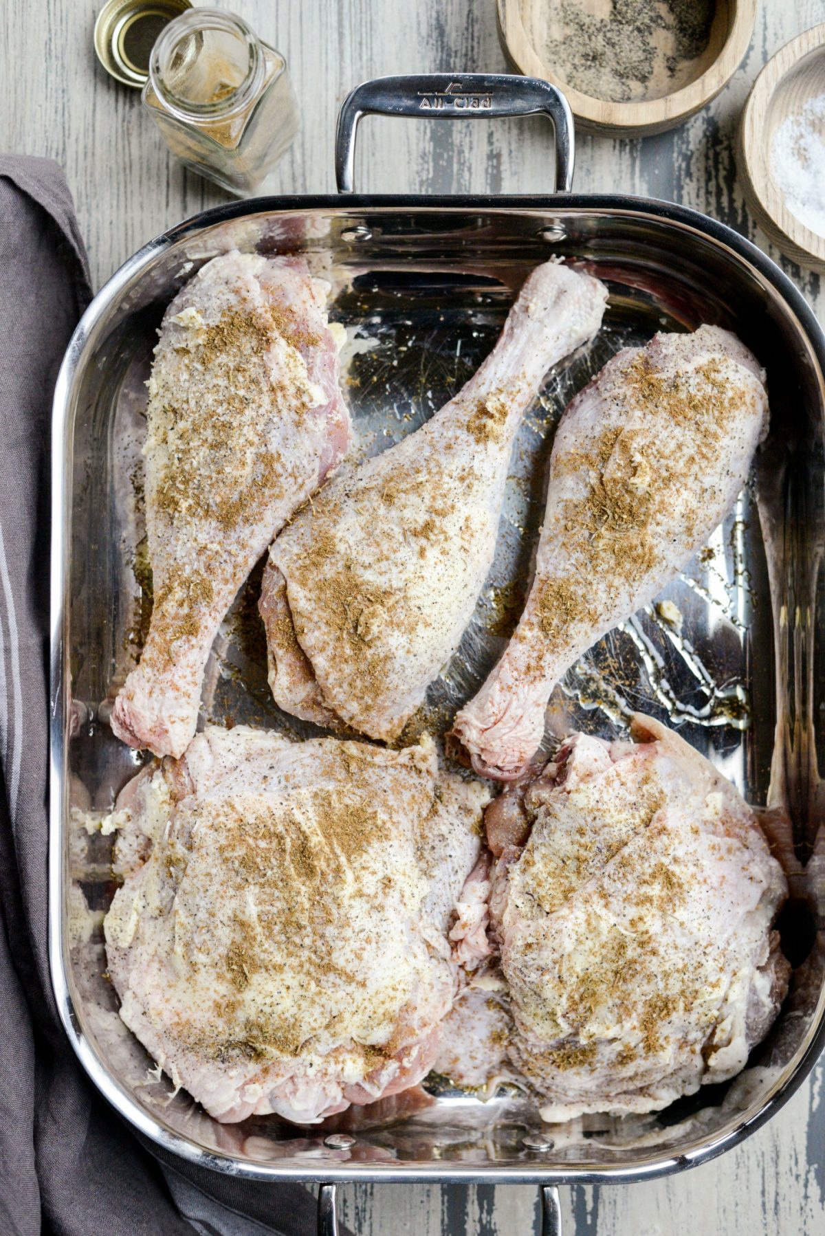 pan full of seasoned turkey thighs and drumsticks.