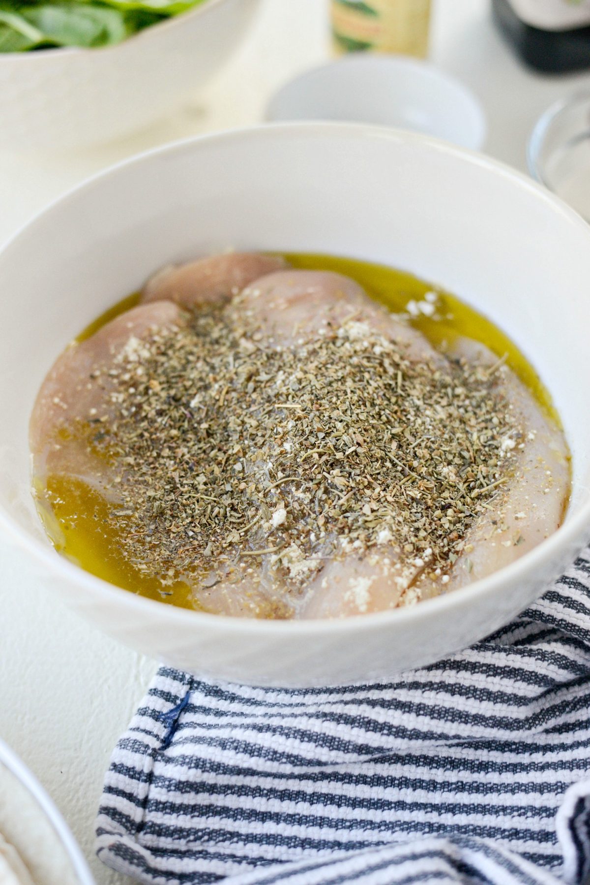 add the chicken to a bowl with olive oil (I eyeball it), lemon juice, Italian seasoning and garlic powder and kosher salt.