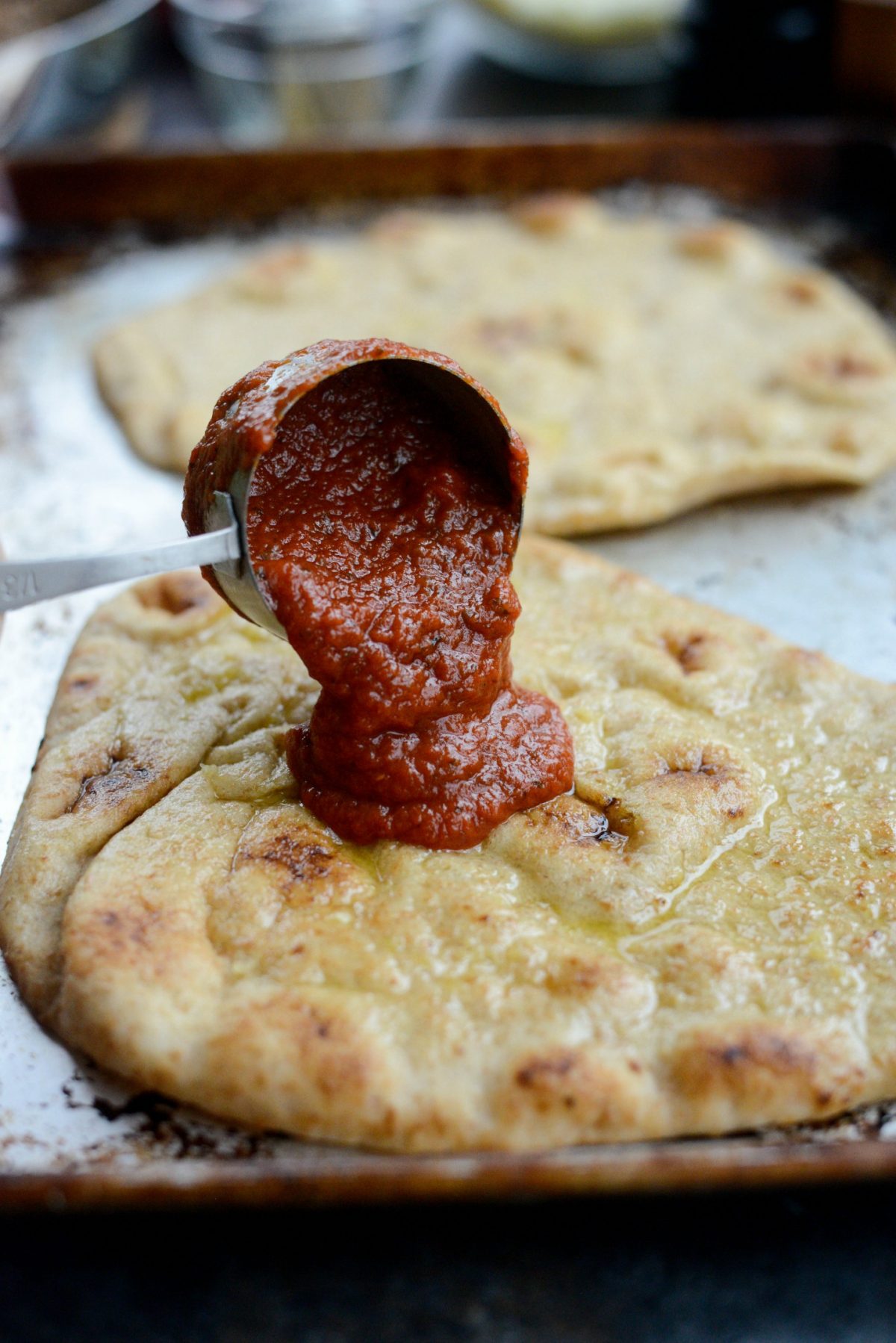 divide and pour the marinara on the naan