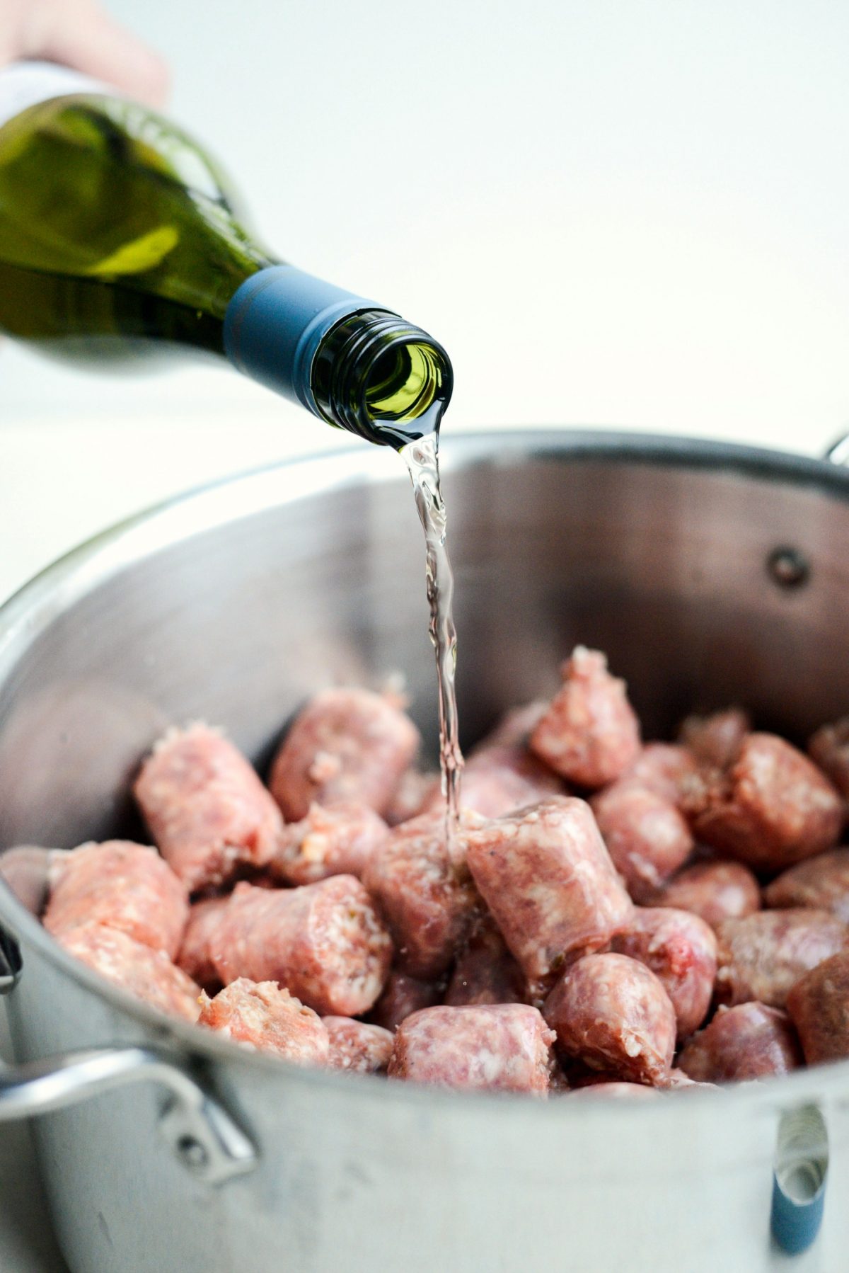 add sausages to a pot with chardonnay 