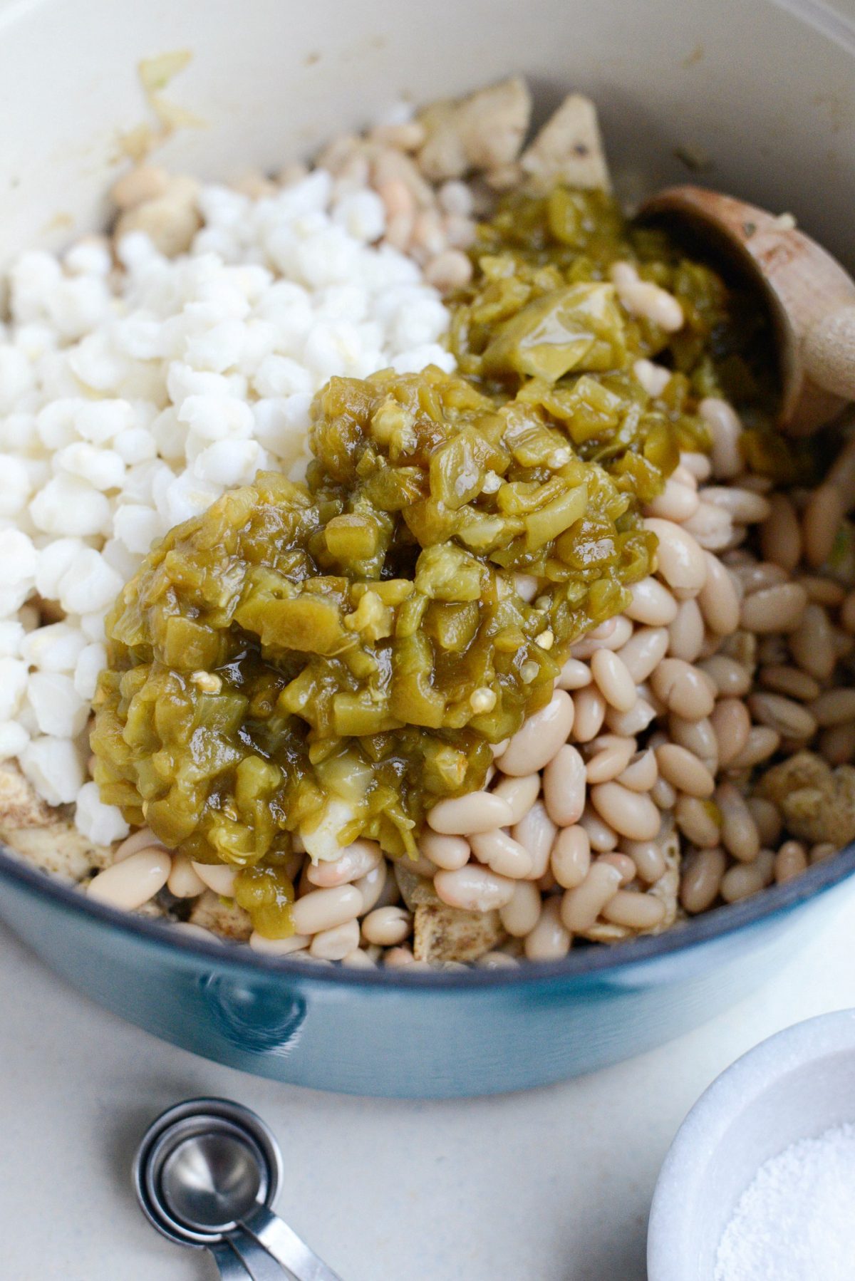 Add in hominy, beans and diced green chiles.