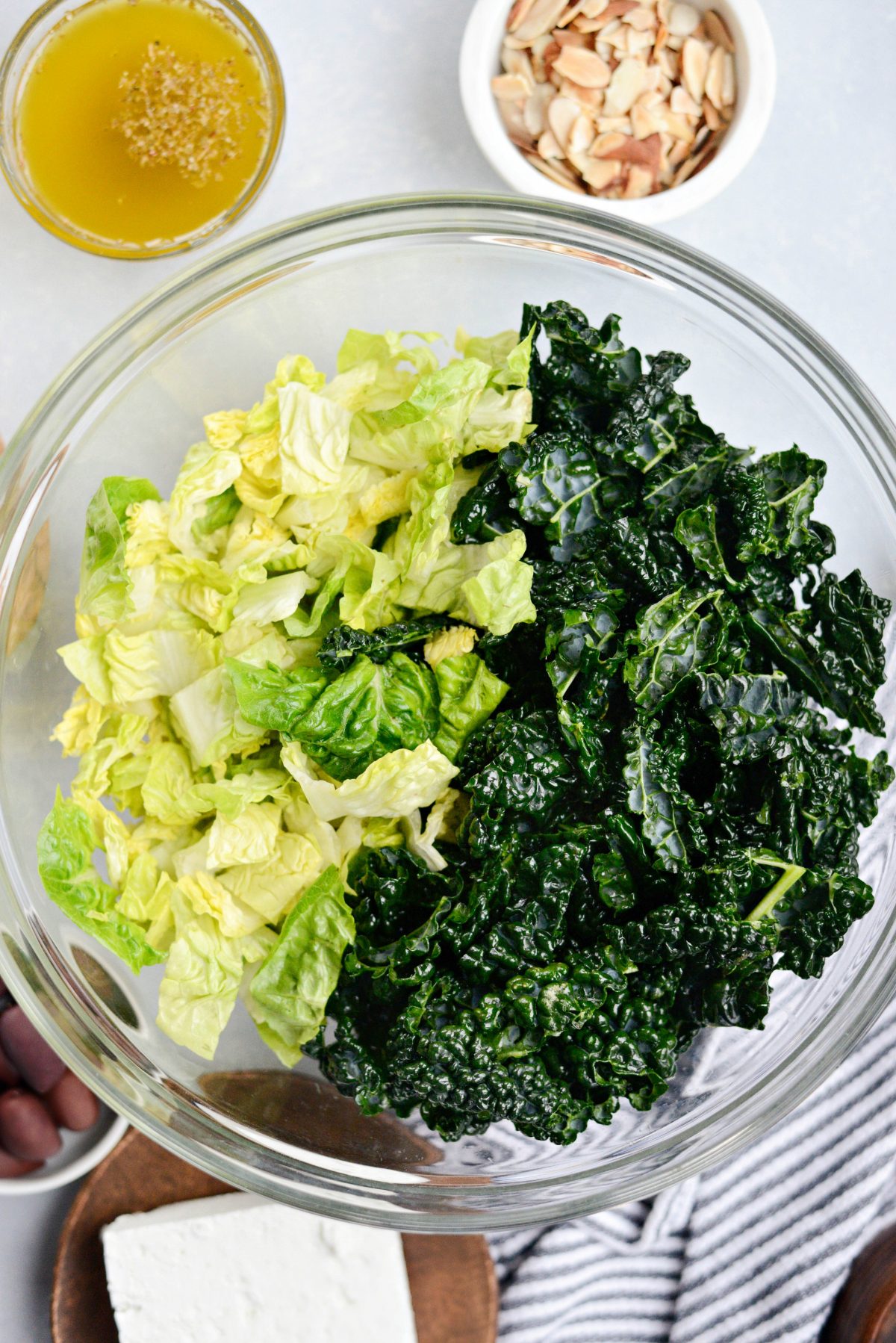 strip the leaves off of the kale and add it to a bowl with chopped romaine