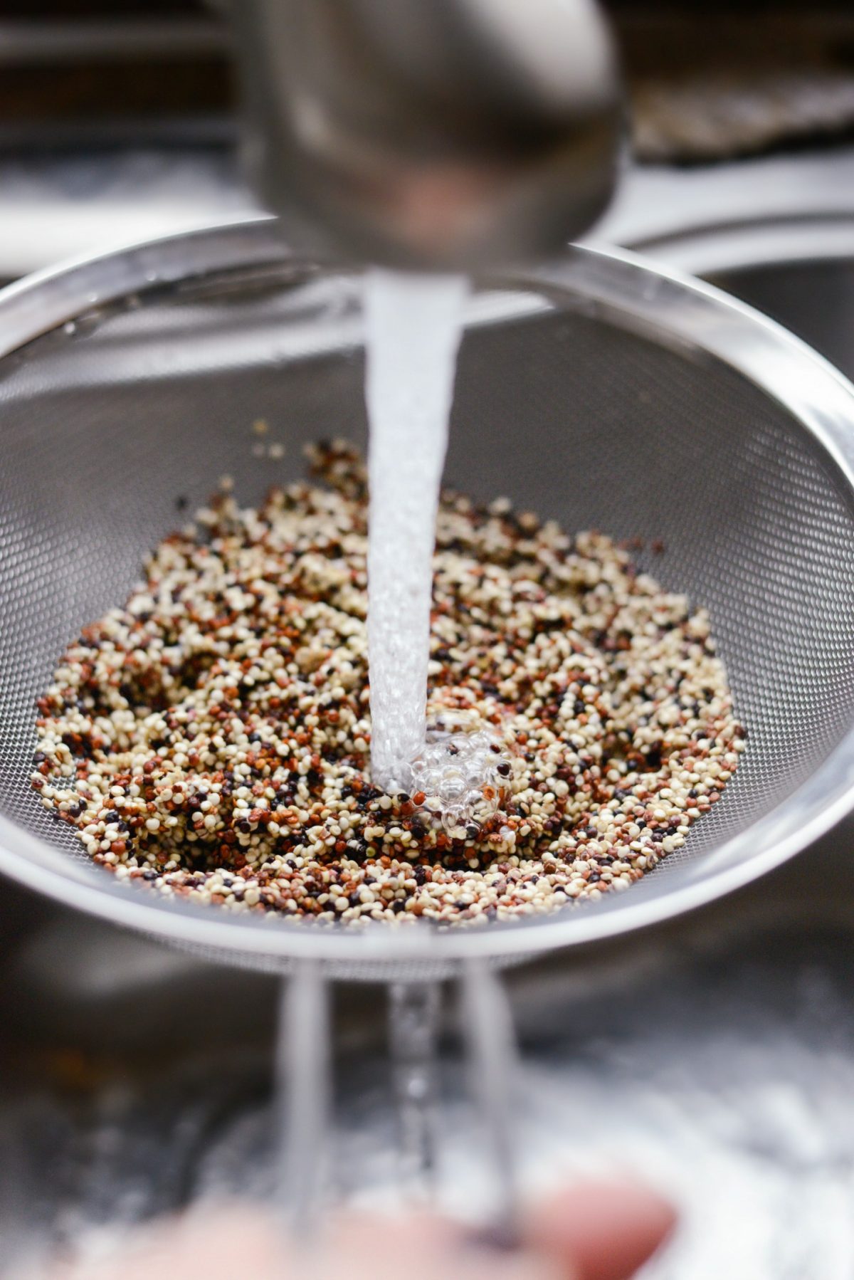 rinsing quinoa under running water