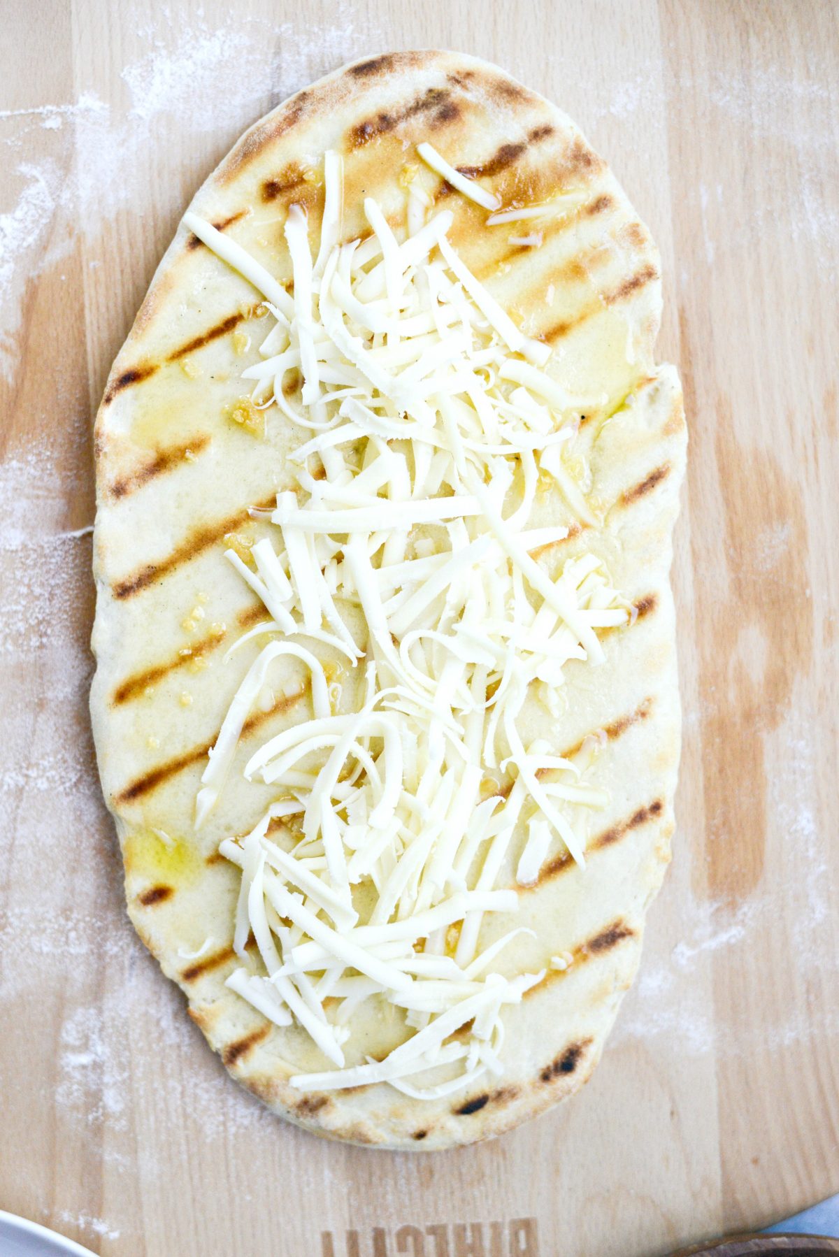 grilled pizza dough topped with garlic oil and cheese