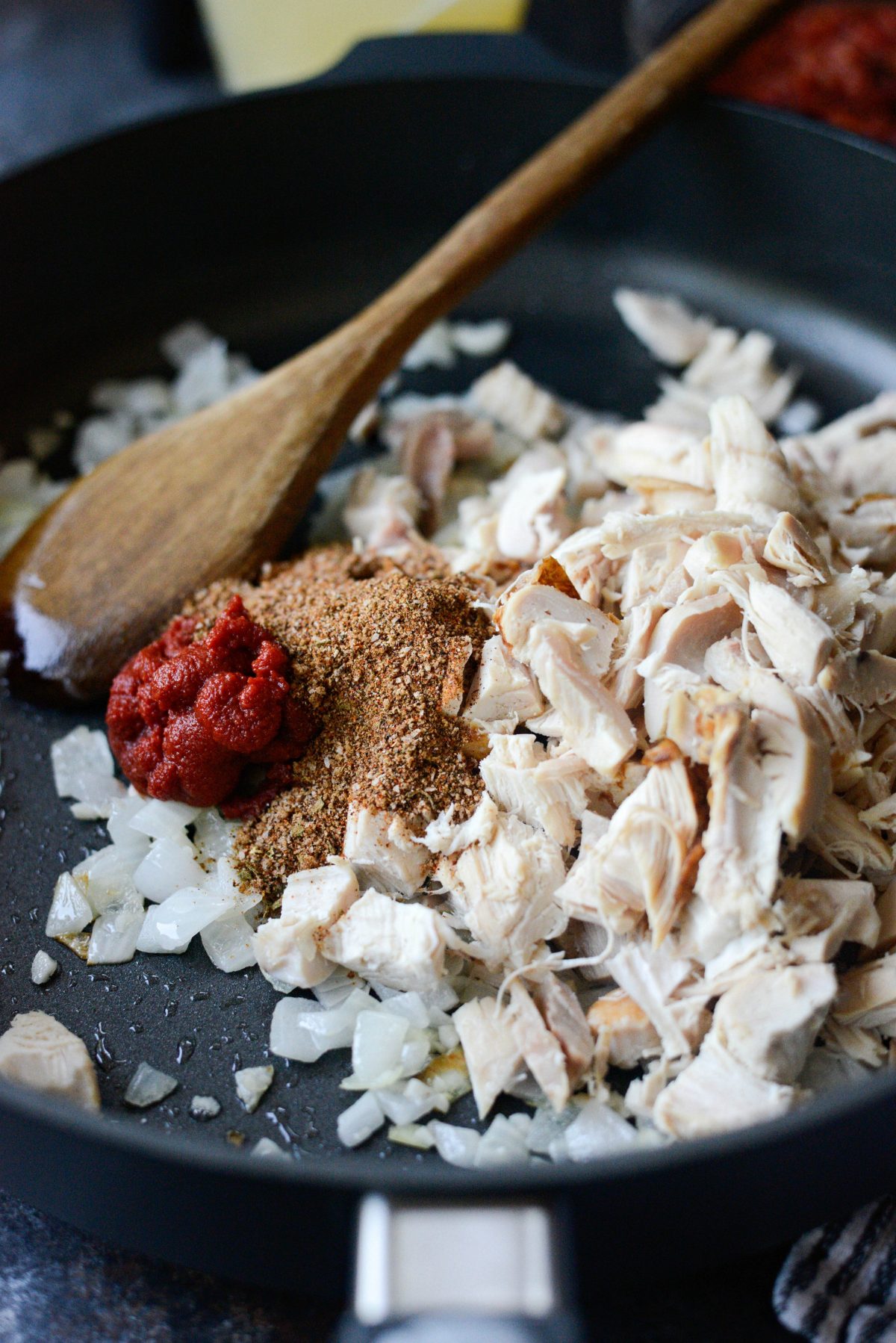 add cooked chicken, spices and tomato paste