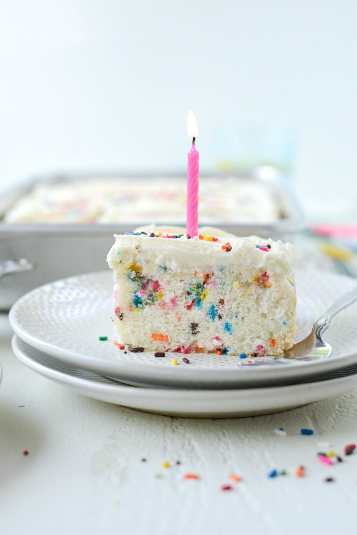 piece of Homemade Funfetti Cake with a lit candle