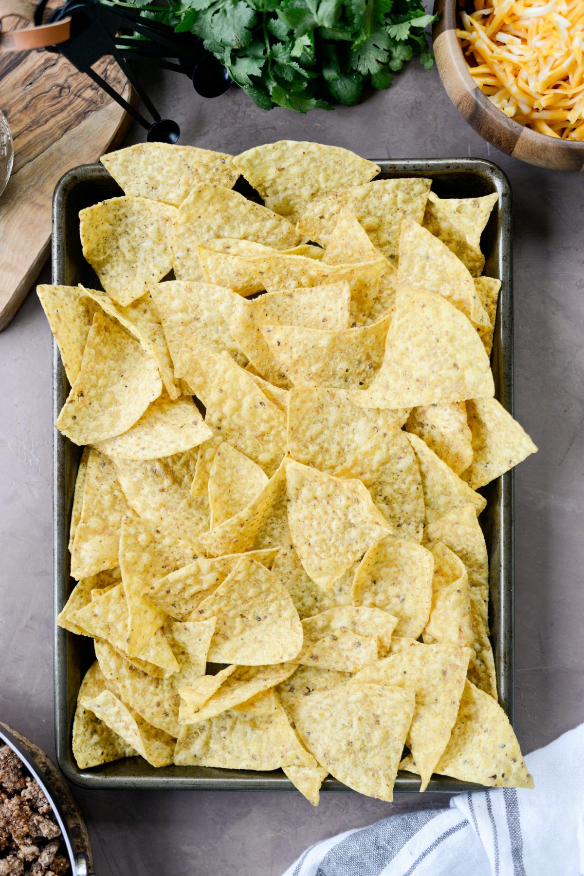 line a small rimmed baking sheet with tortilla chips.
