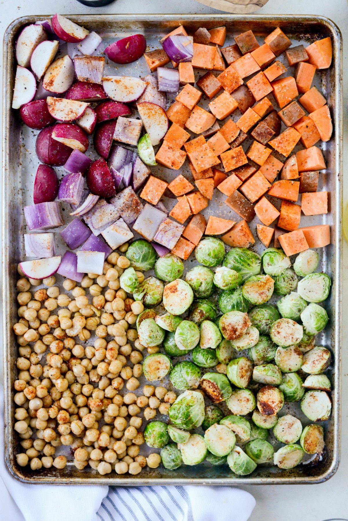 seasoned prepped veggies on a sheet pan