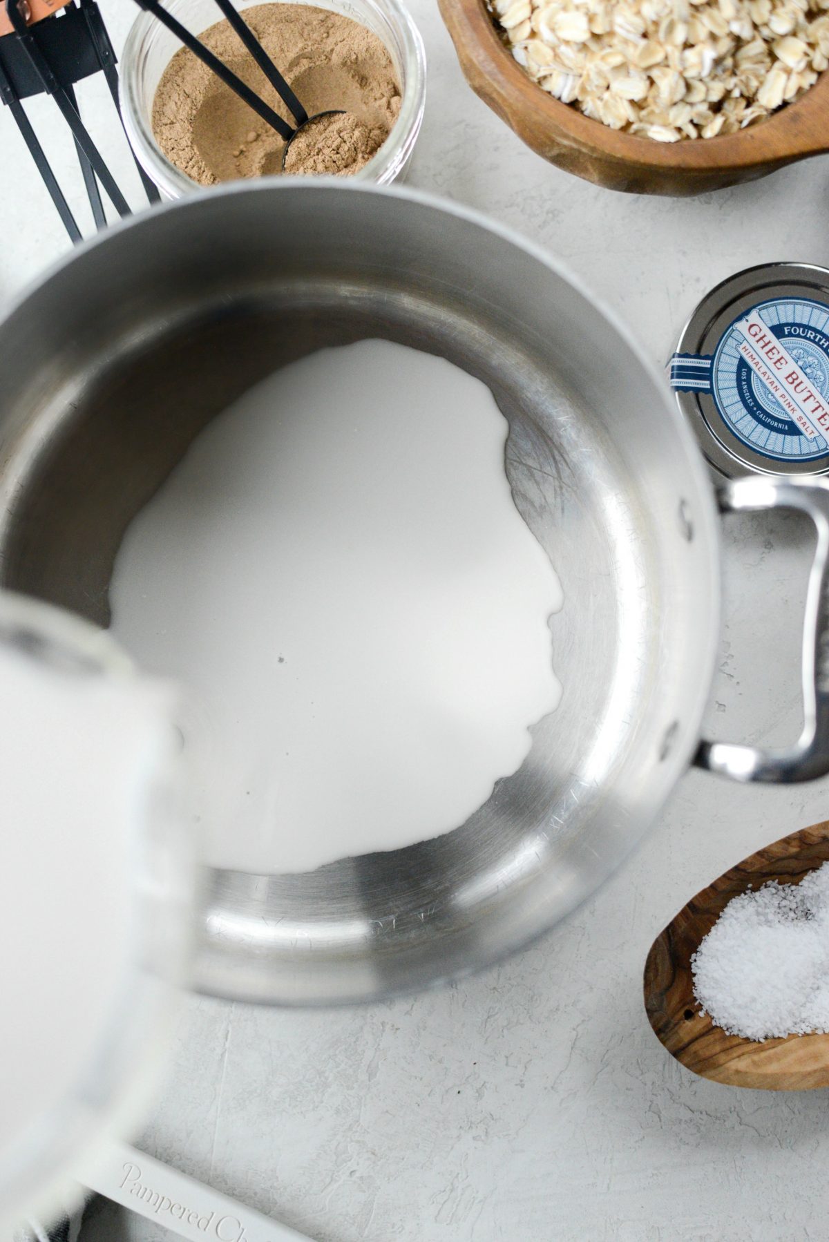 pouring milk into a saucepan.