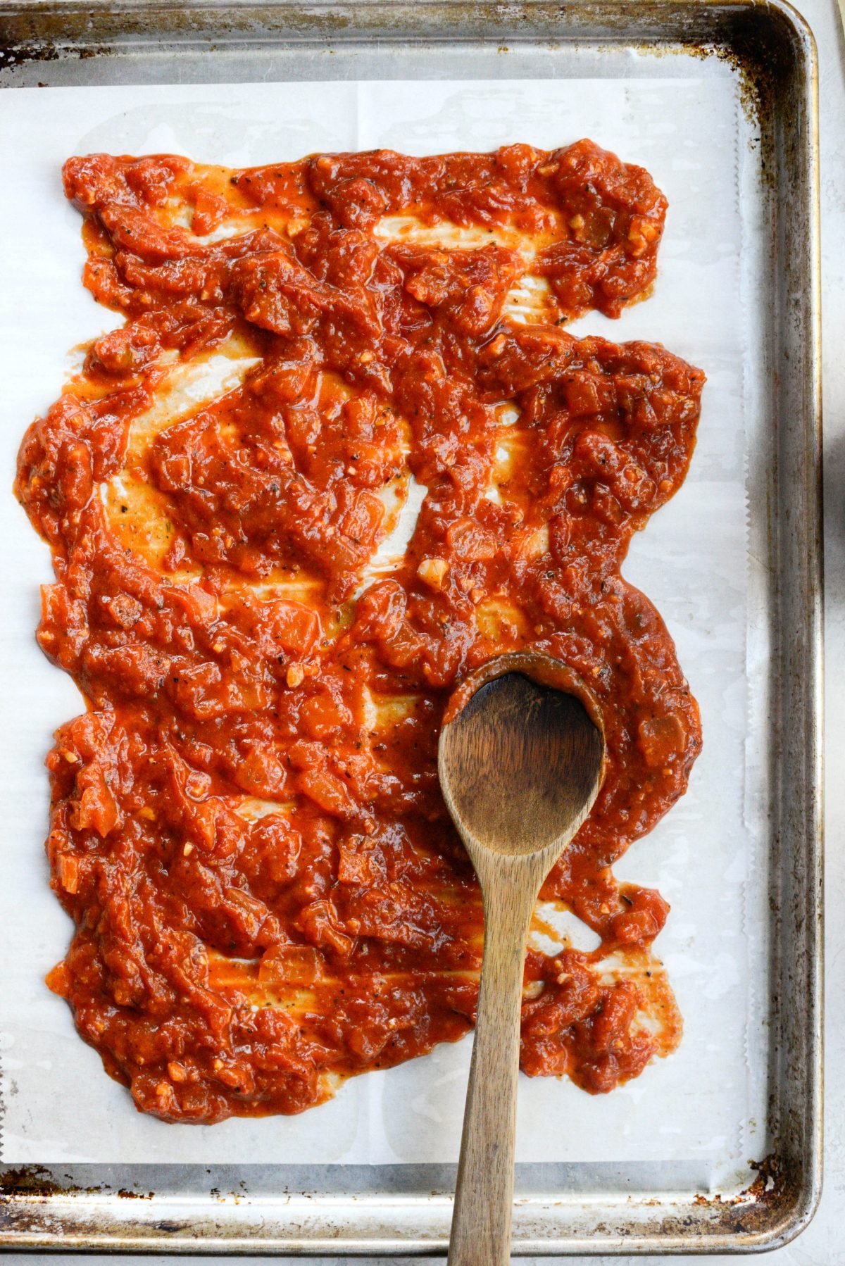 spread sauce on rimmed sheet pan