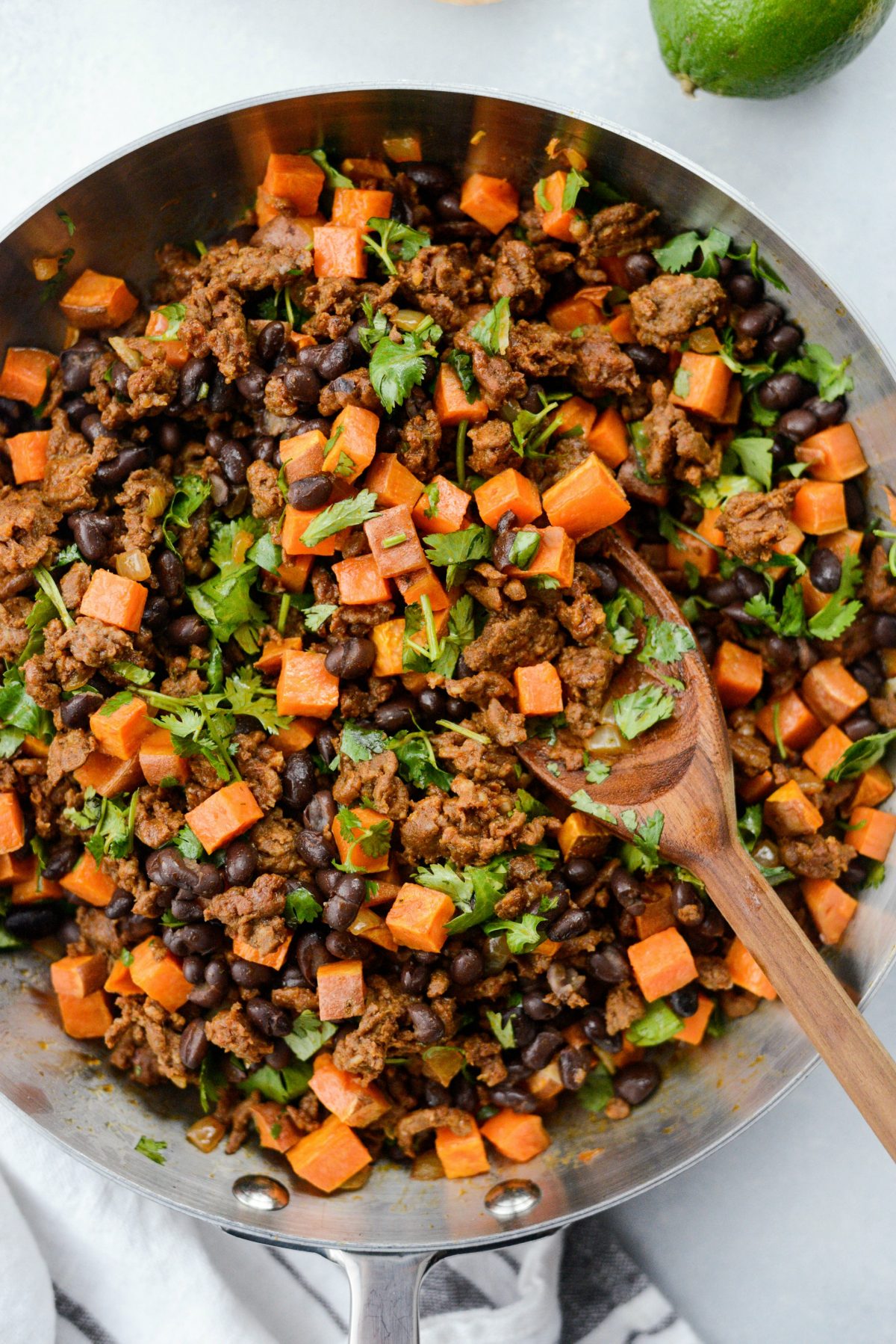 skillet of Chorizo Sweet Potato Black Bean Taco filling with wooden spoon