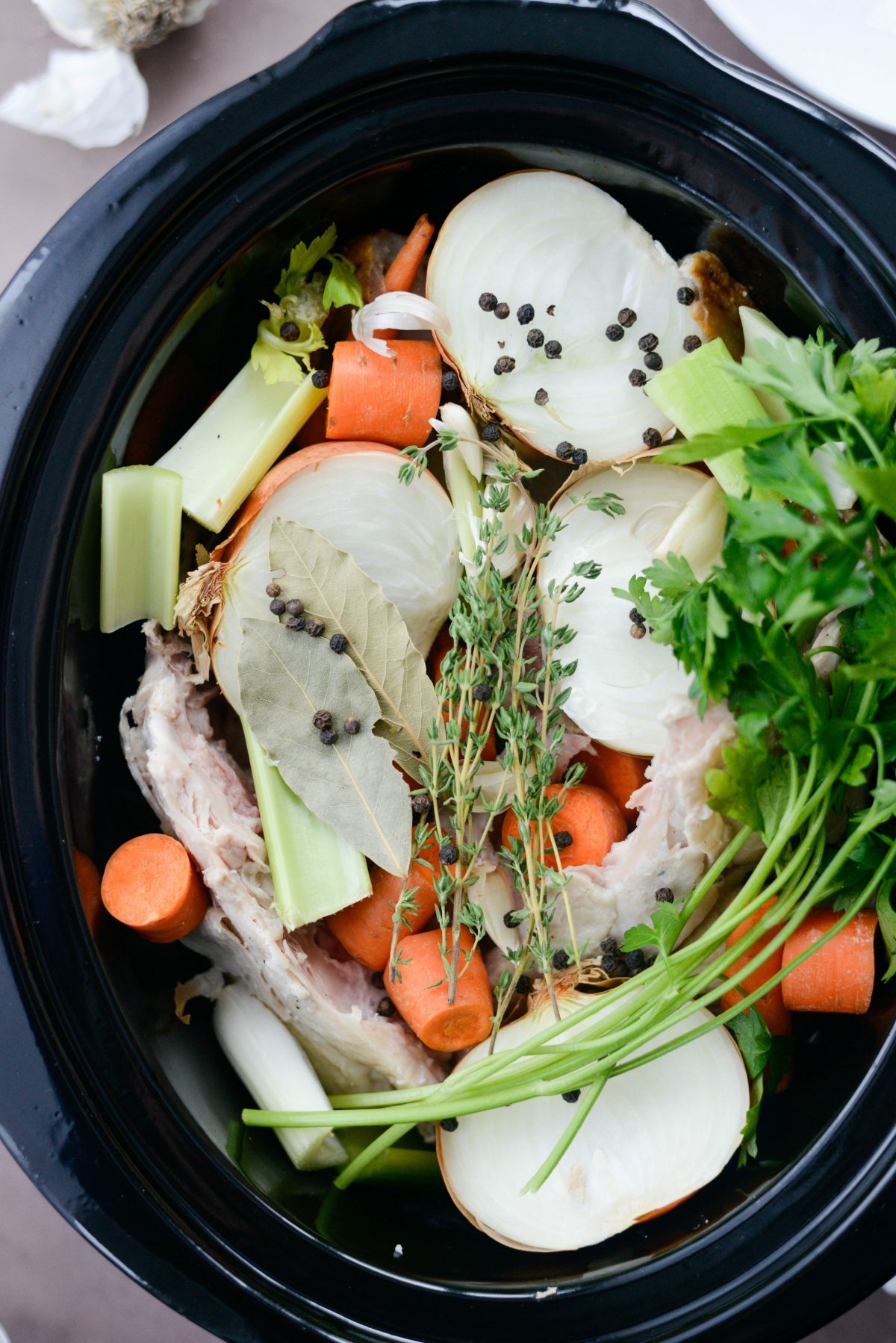 herbs and peppercorns added to slow cooker