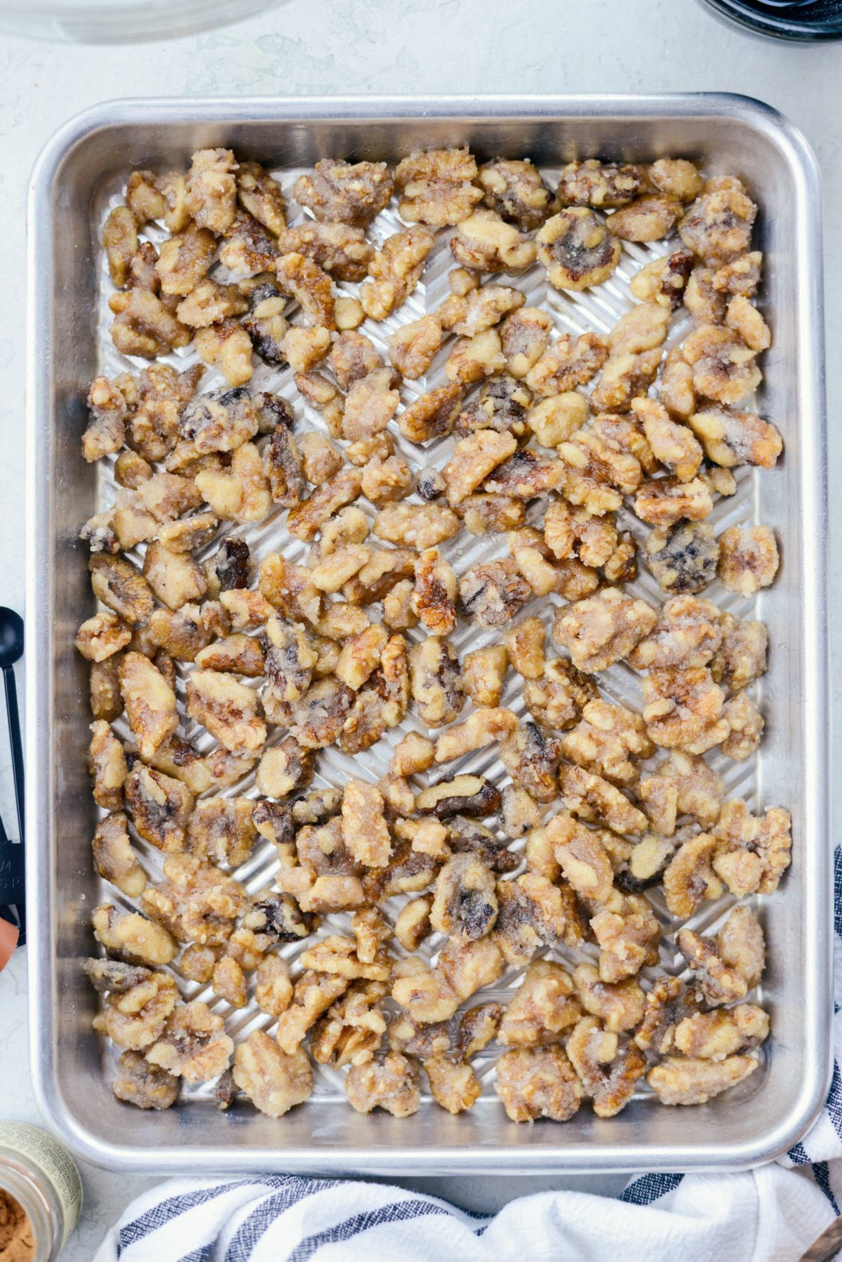 spread coated walnuts on rimmed baking sheet