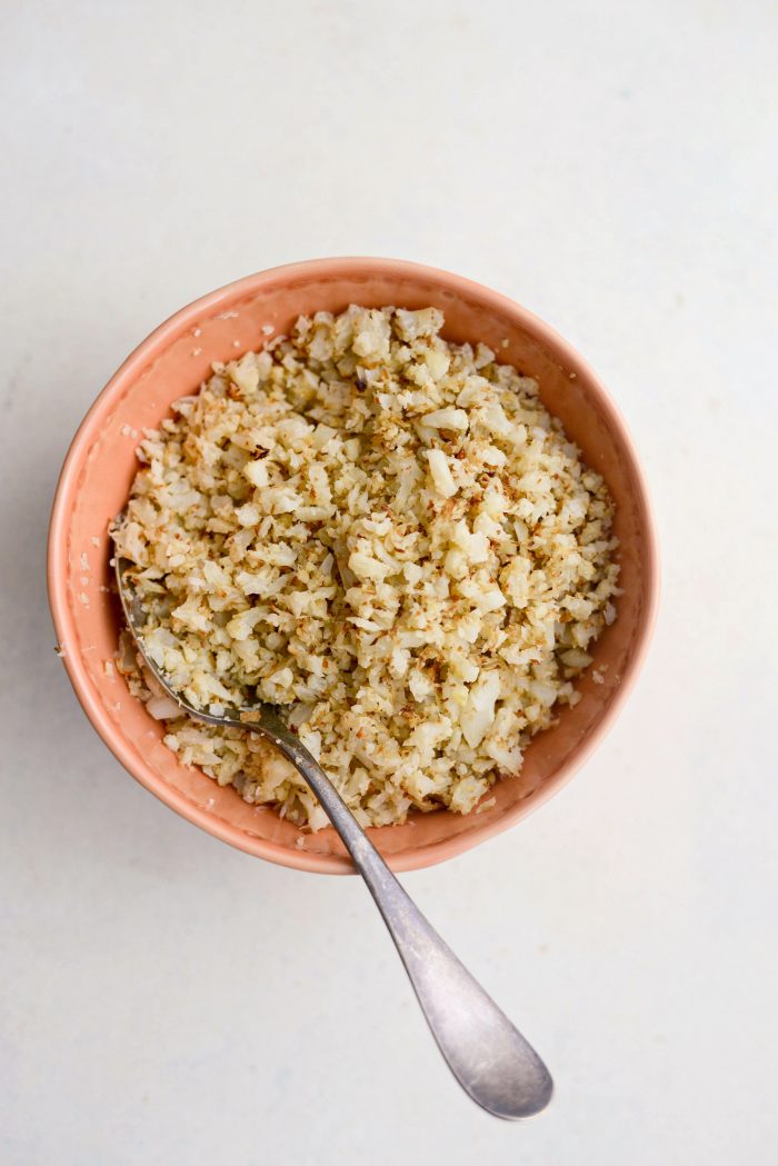 Roasted Cauliflower Rice in orange bowl with spoon