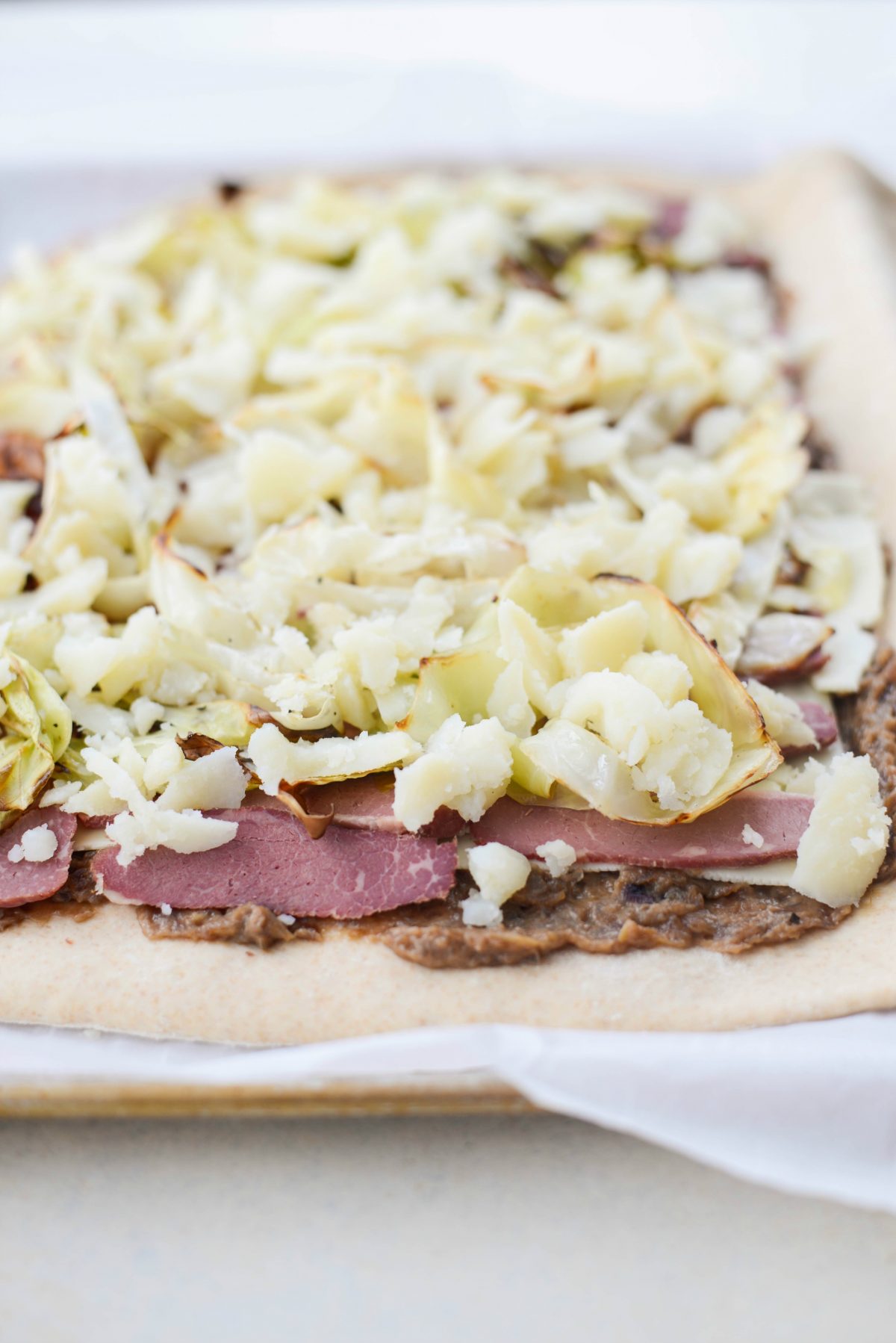 top with onions (if using), corned beef, chopped roasted. cabbage and crumbled cooke potatoes.