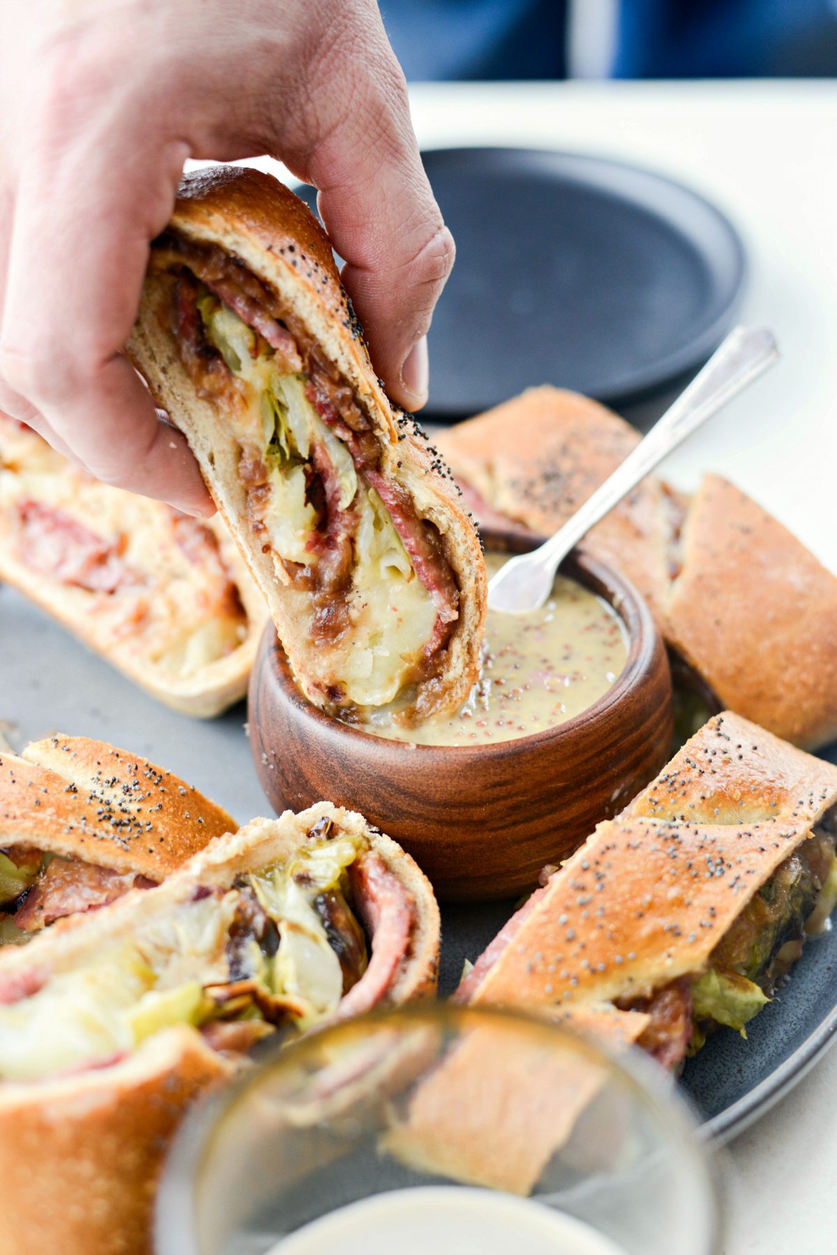 Dipping Corned Beef and Cabbage Stromboli into Guinness Mustard