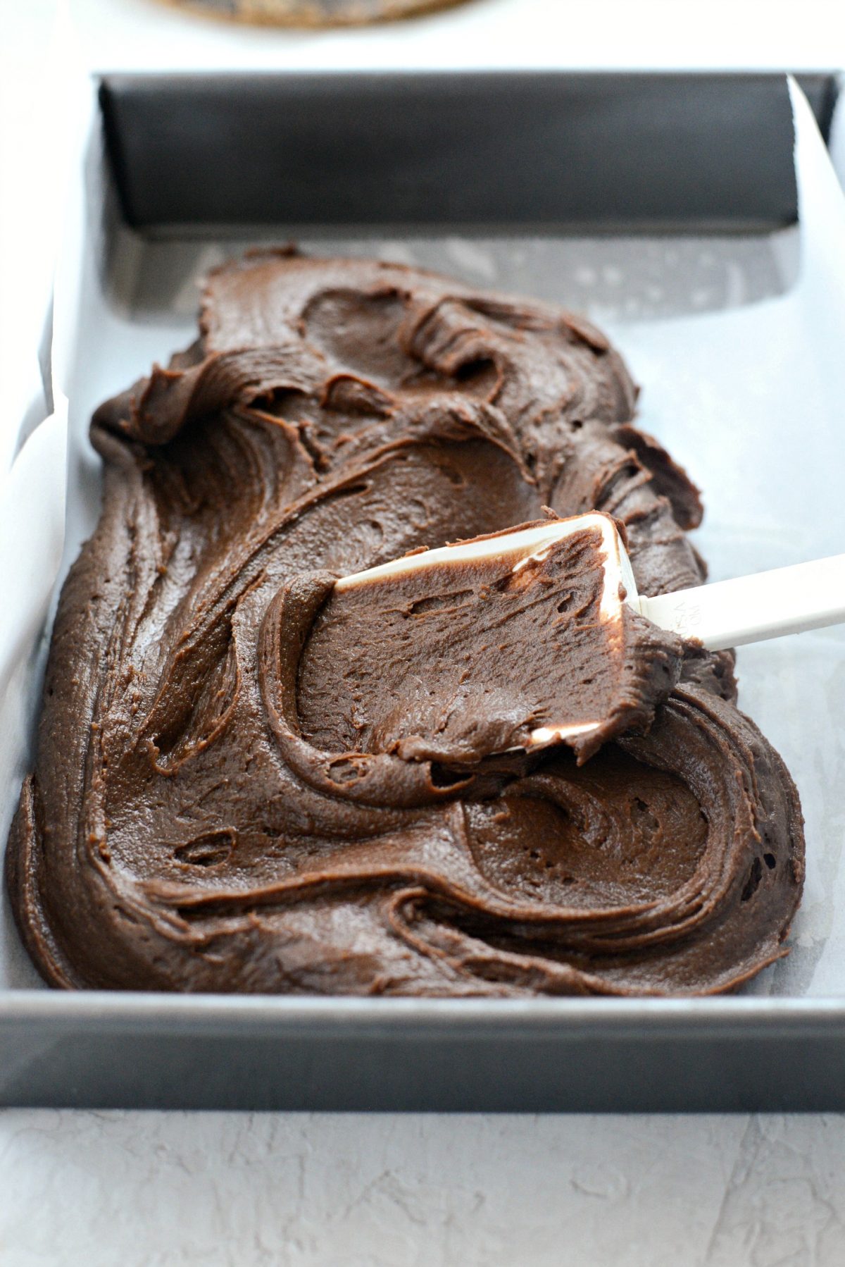 spreading brownie batter in pan