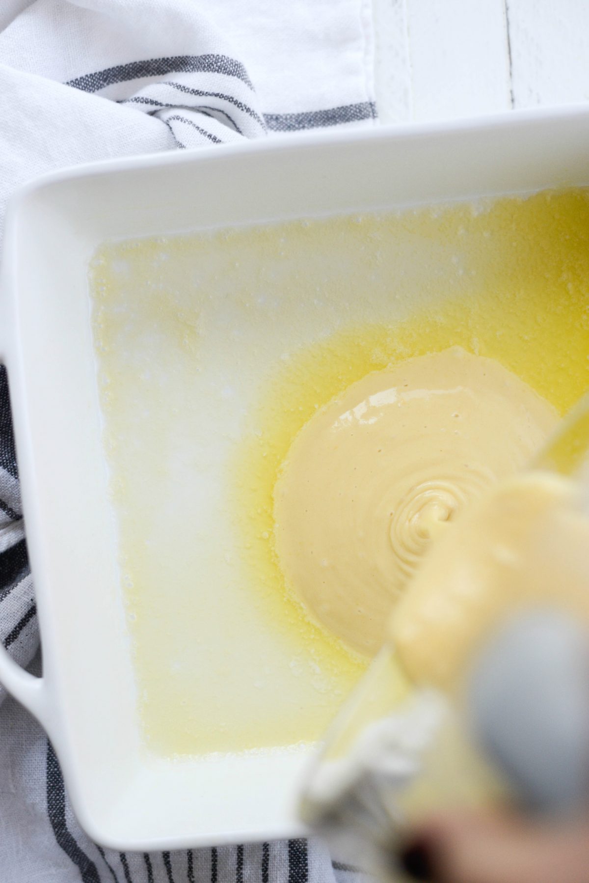 pouring pancake batter into hot butter/pan.