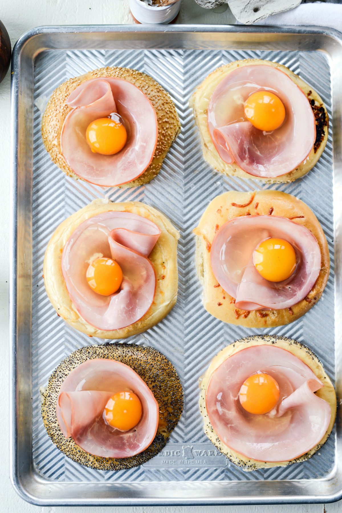 add ham and crack in one egg per bagel.