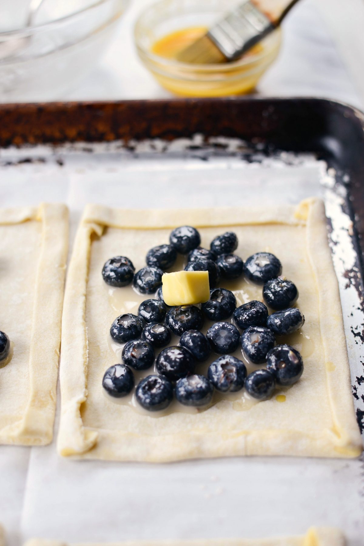divide blueberries among puff pastry squares and dot with butter