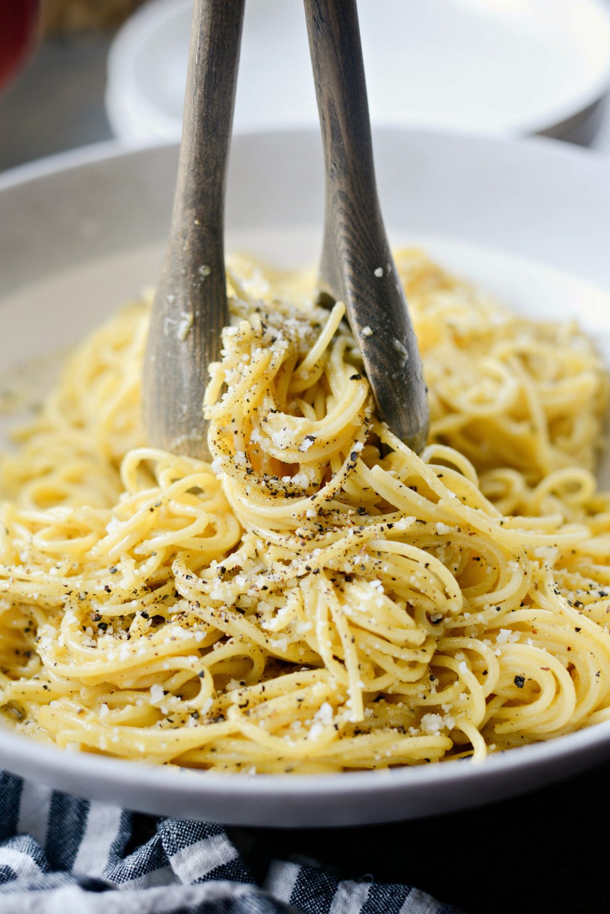 serving Cacio e Pepe Carbonara with wooden spoons