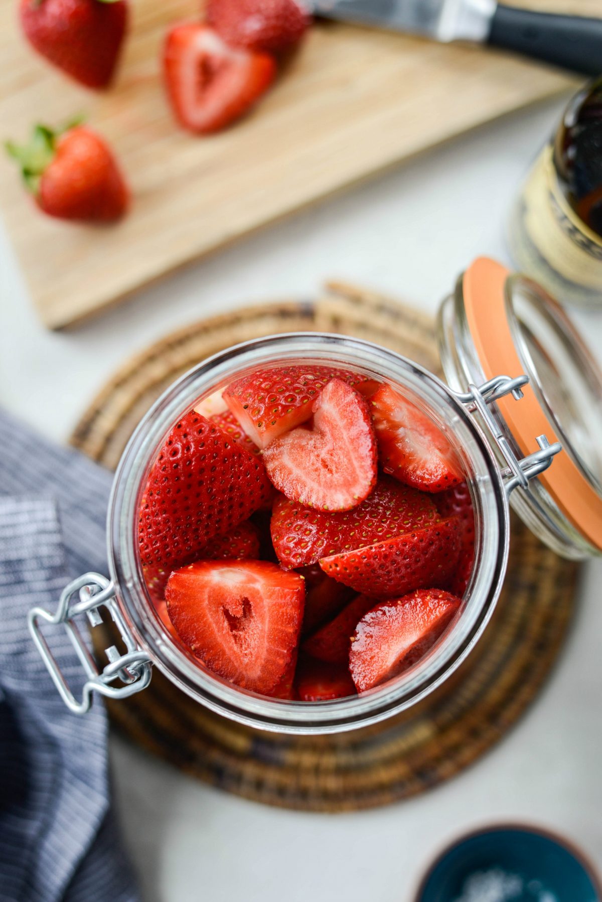 add halved strawberries to a jar.