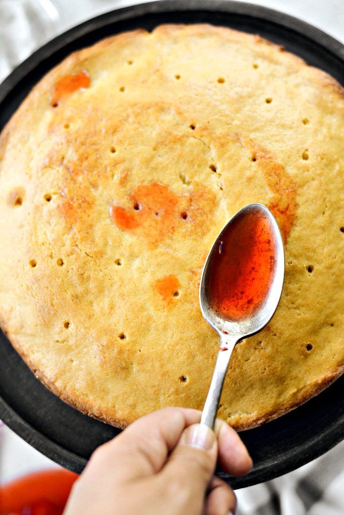spoon syrup over cake poked with holes
