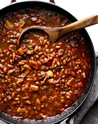 wooden spoon in red pot with one pot wicked baked beans