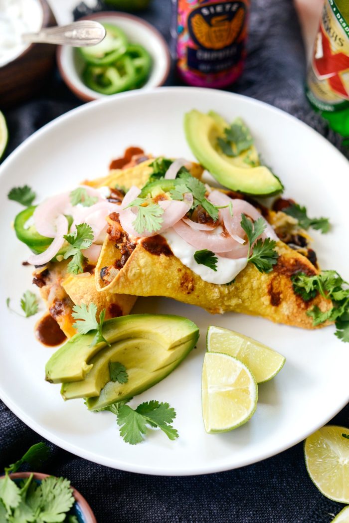 Crisp air fried chipotle chicken black bean tacos on white plate with toppings