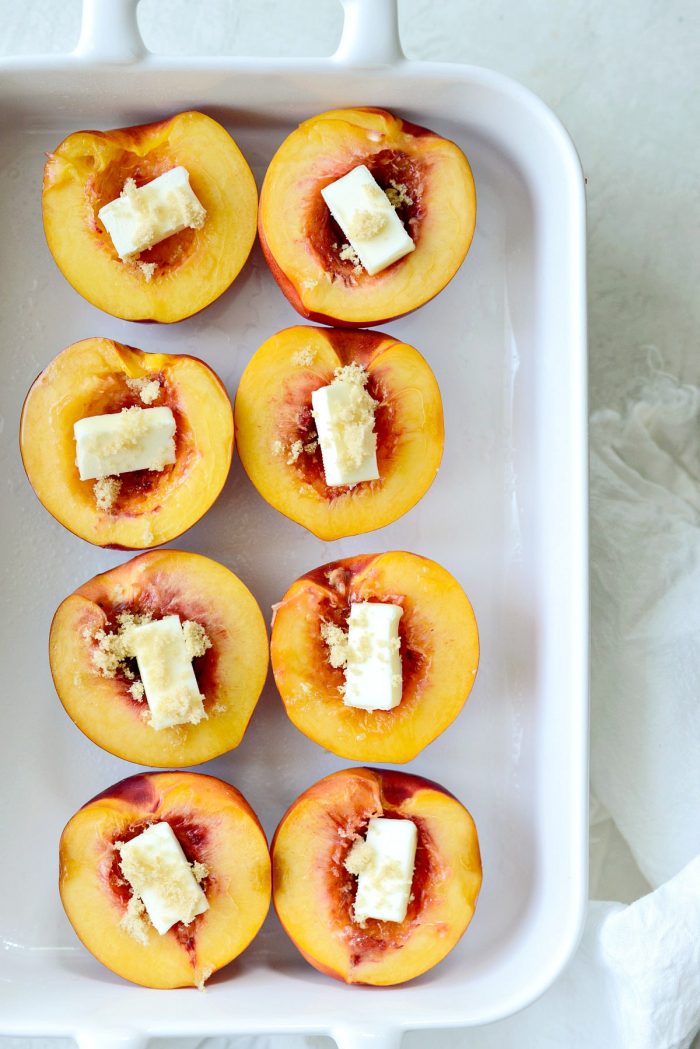 nectarine halves with butter and brown sugar in white dish