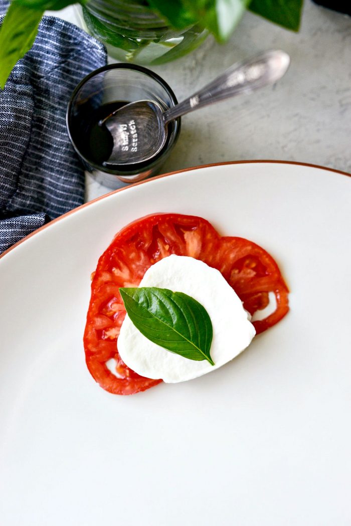 build the platter with a slice of tomato, mozzarella and basil