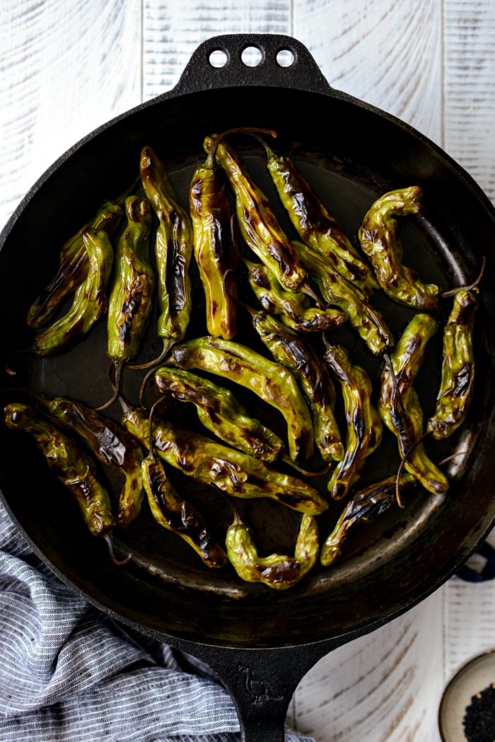 blistered shishito peppers in skillet