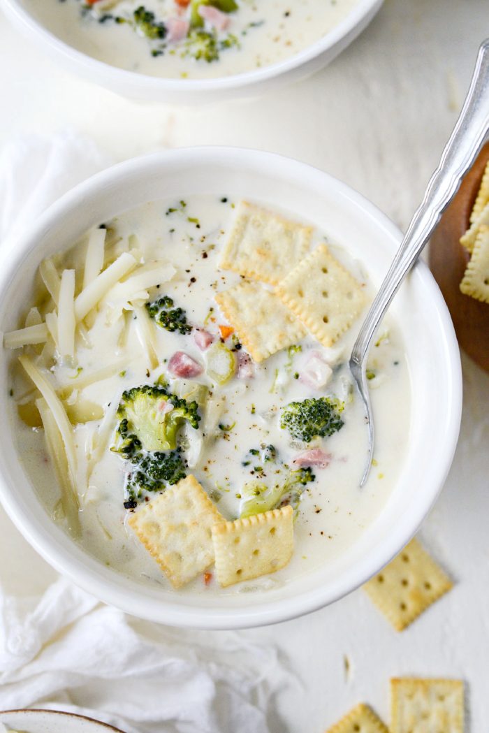Broccoli Ham and Swiss Soup with crackers in a white bowl.