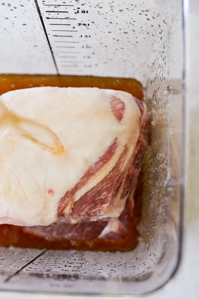 poring cold brine over pork shoulder