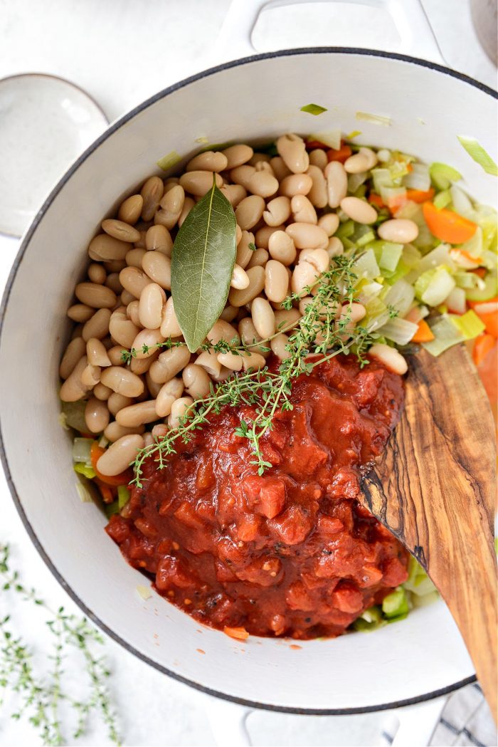 add the crushed tomatoes, beans, bay leaf and thyme in white dutch oven.