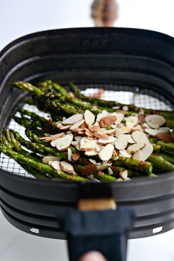 almonds and balsamic asparagus in air fryer basket.