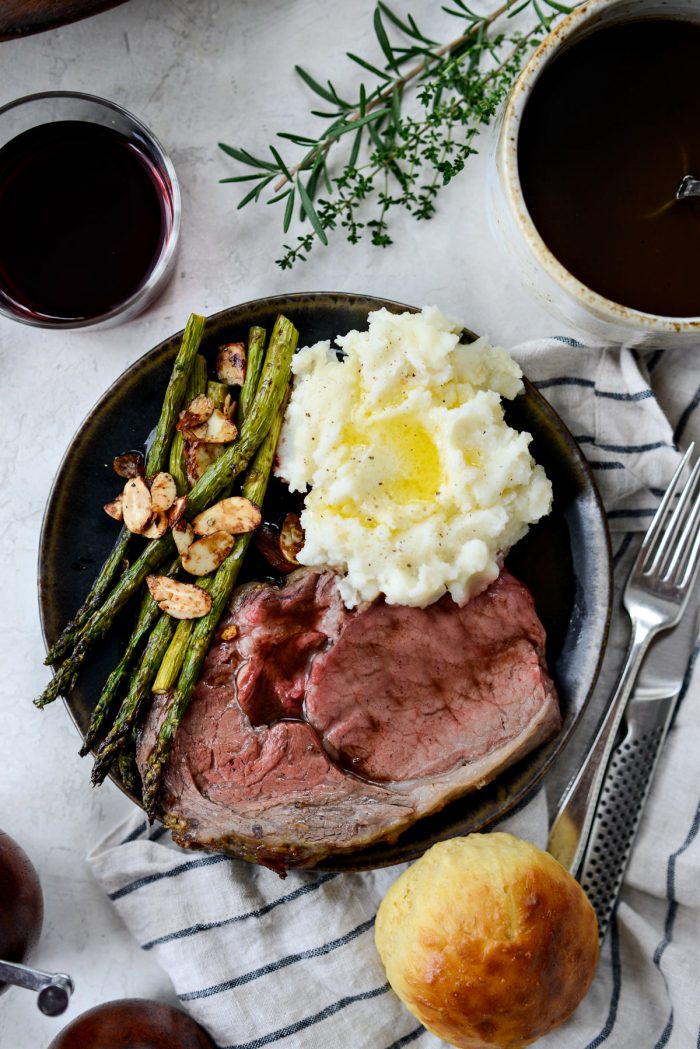 Dijon Rosemary Prime Rib Roast on a black plate with sides.