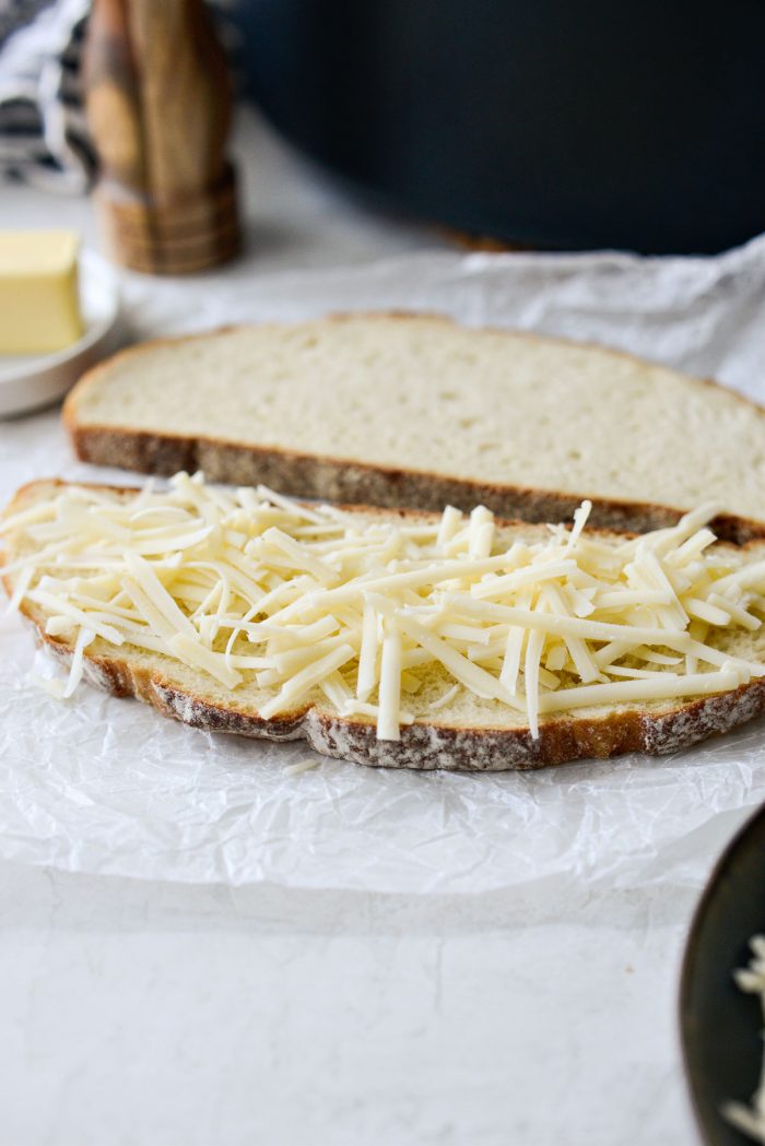 slice of sourdough with shredded gruyere.