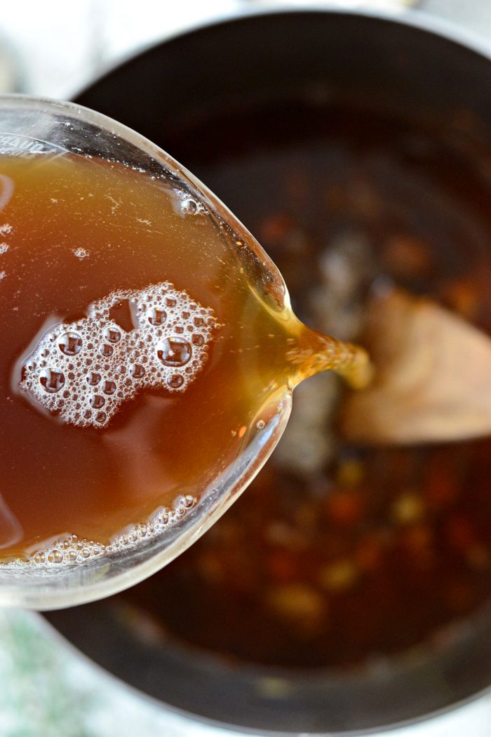 pouring in beef broth.