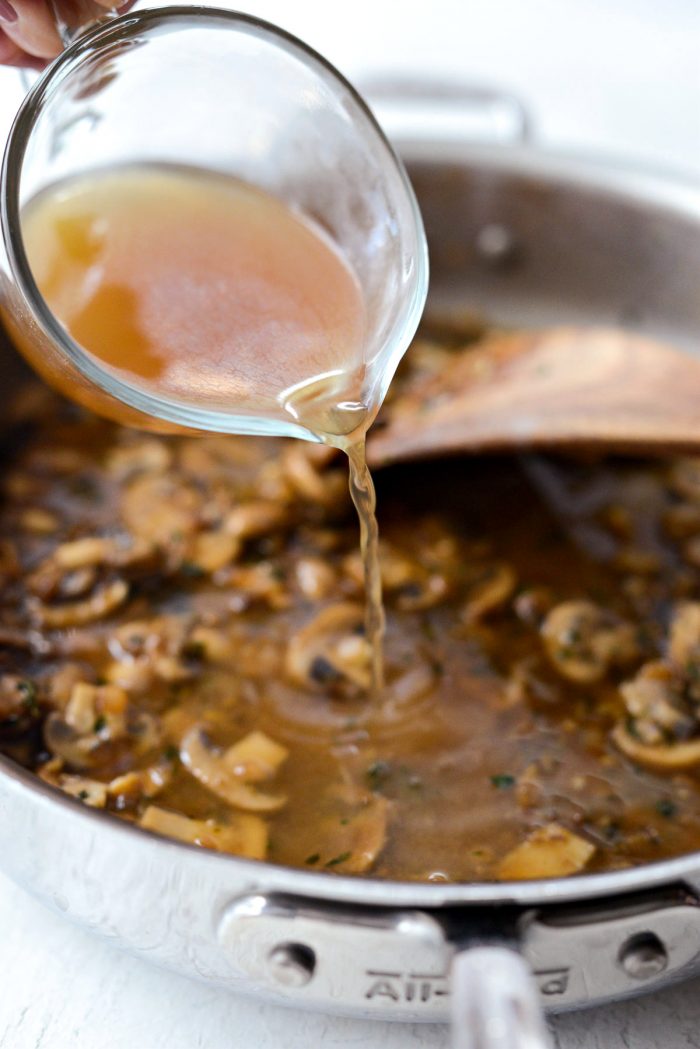 chicken stock being poured into skillet.