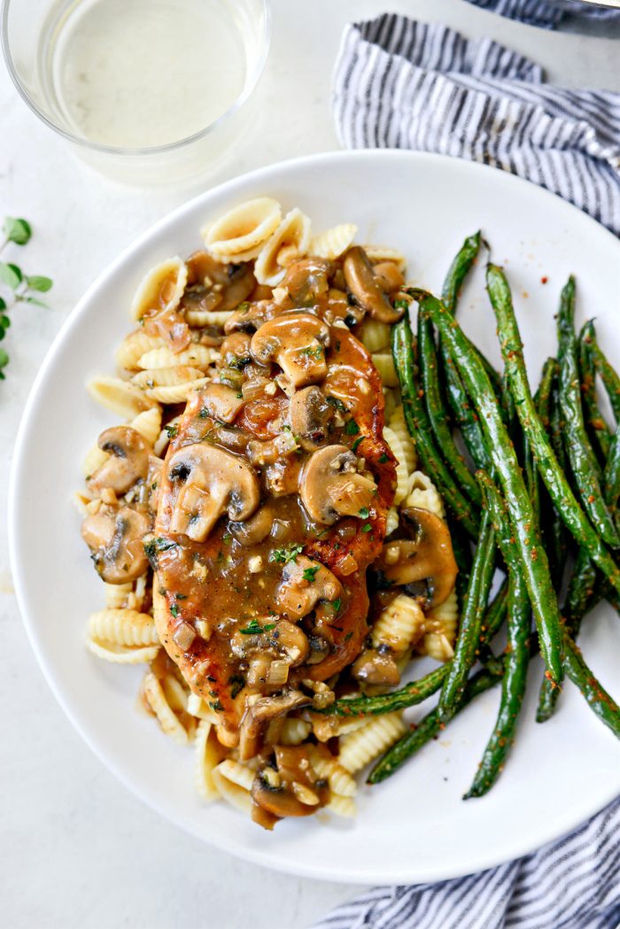 Lighter chicken marsala on white plate with green beans and pasta.