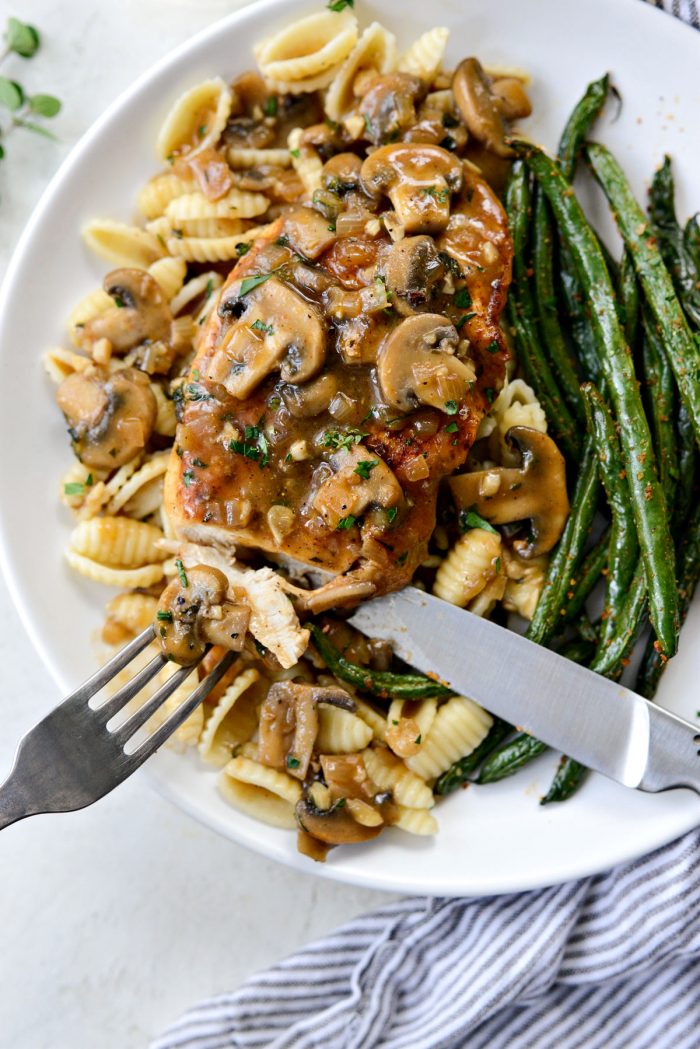 close up of cut chicken Marsala with mushroom.