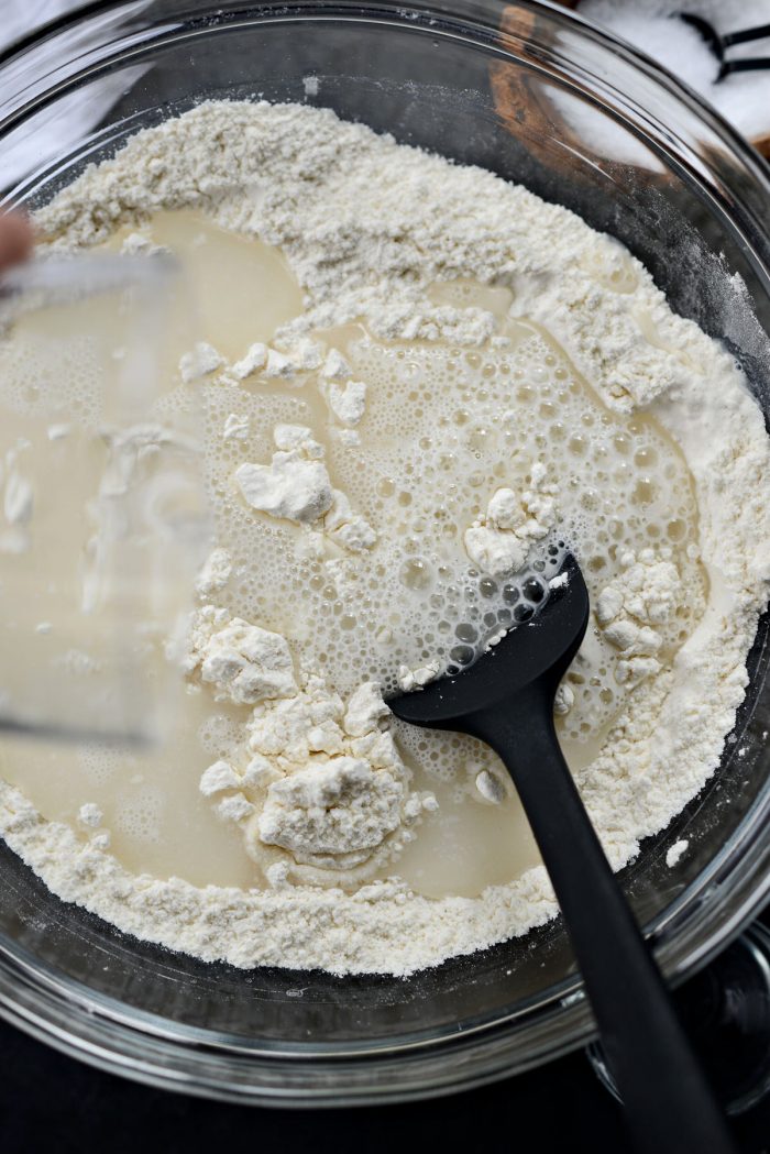 gradually stirring water into dry ingredients.