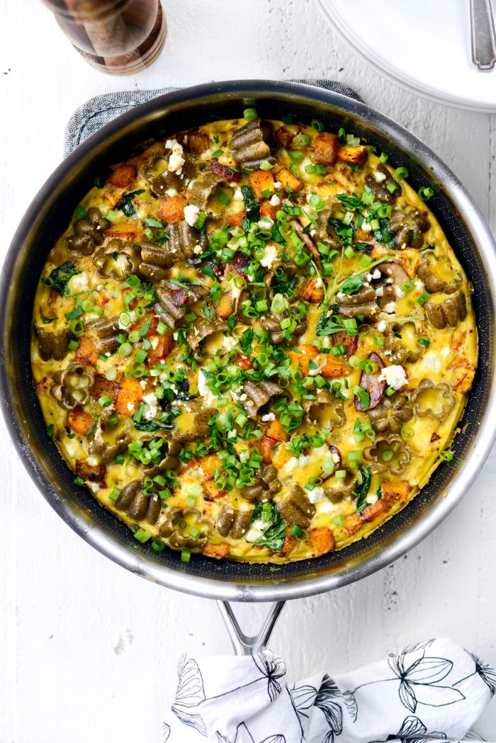 Roasted Pumpkin Kale and Feta Frittata in skillet with green onion and minced parsley.