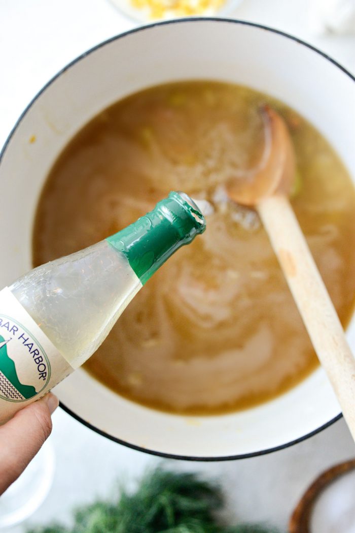 pouring clam juice into soup.