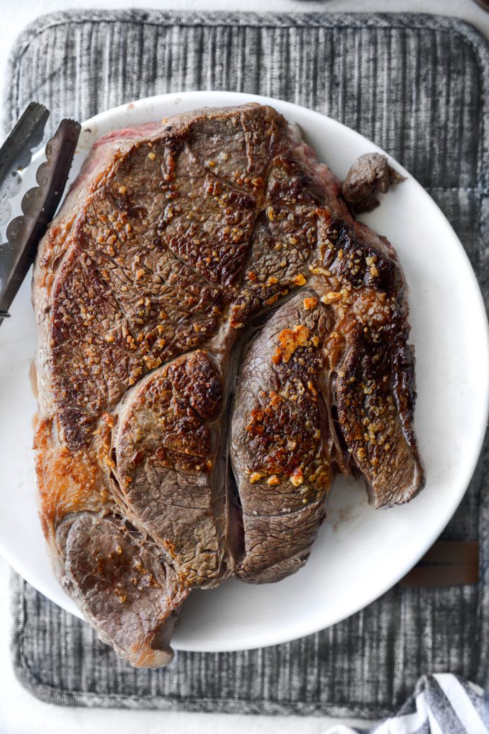 seared chuck roast on a white plate.