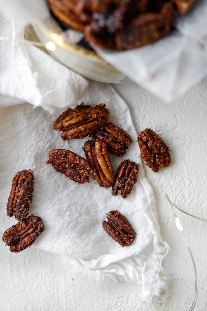 scattered Honey Vanilla Bourbon Pecans on a white linen napkin. 